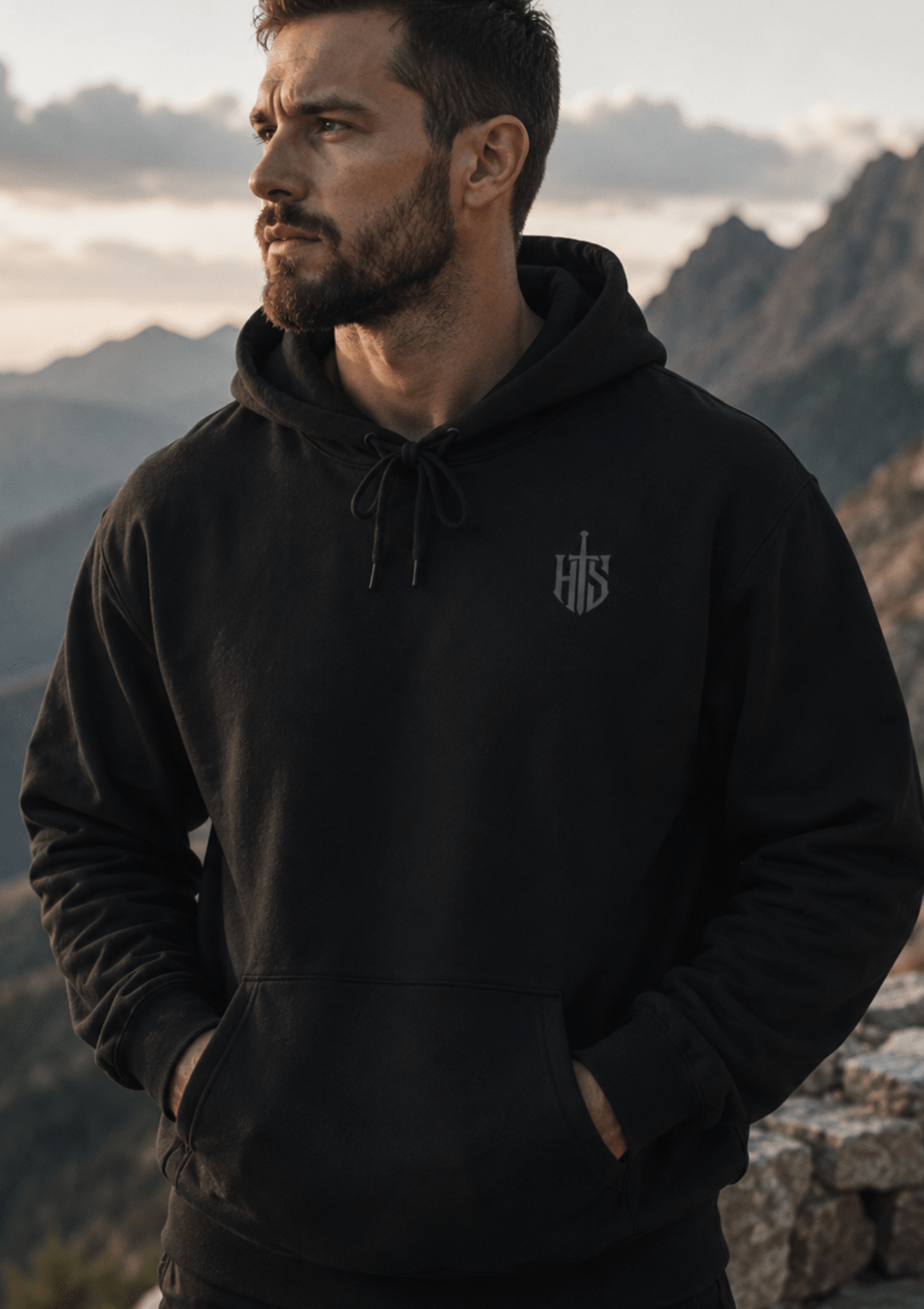 Black Hilt and Stone core hoodie with shield emblem worn outdoors