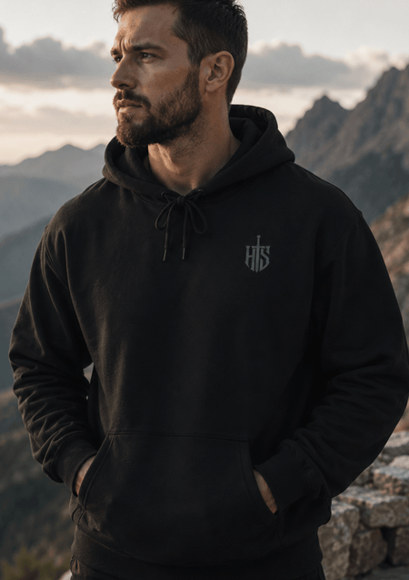Black Hilt and Stone core hoodie with shield emblem worn outdoors